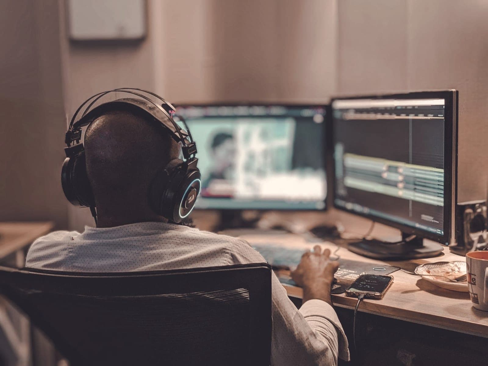 Video editor working on footage across dual monitors