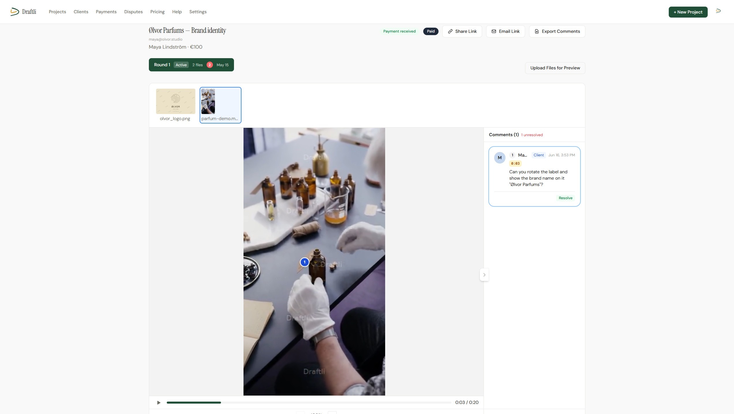 Draftli video proofing review page: a client's brand video paused at 0:03 with a numbered annotation pin on the frame and a time-coded comment asking to rotate the label so the brand name shows
